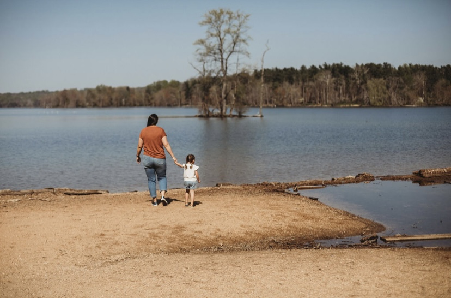 Mother and child walking together by a peaceful lake